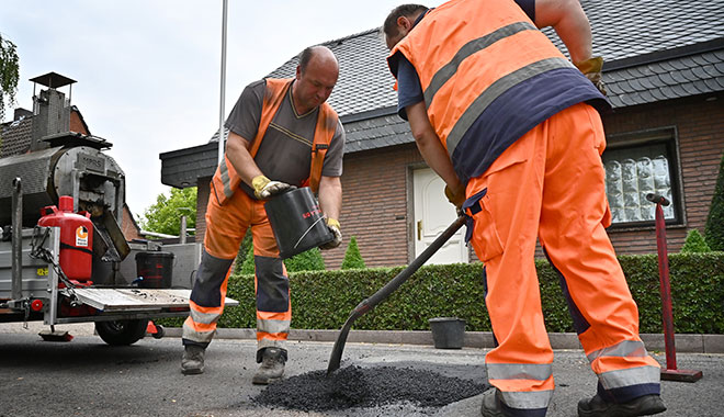 Michael Claßen (links) und Ralf Beser sind mit der neuen Technik des "Mobile Pave Repair System" auf Krefelds Straßen unterwegs (hier im Oldenburger Weg). Foto: Stadt Krefeld, Presse und Kommunikation, A. Bischof