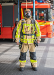 Der Feuerwehrmann legt bzw. zieht die Atemschutzmaske und die Flammschutzhaube an. Brandrauch ist sehr gefährlich, er enthält unter anderem das giftige Kohlenmonoxid.