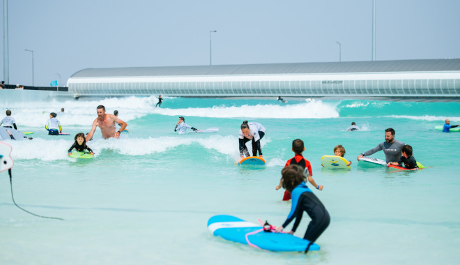 Kinder spielen in den Wellen eines Surfparks